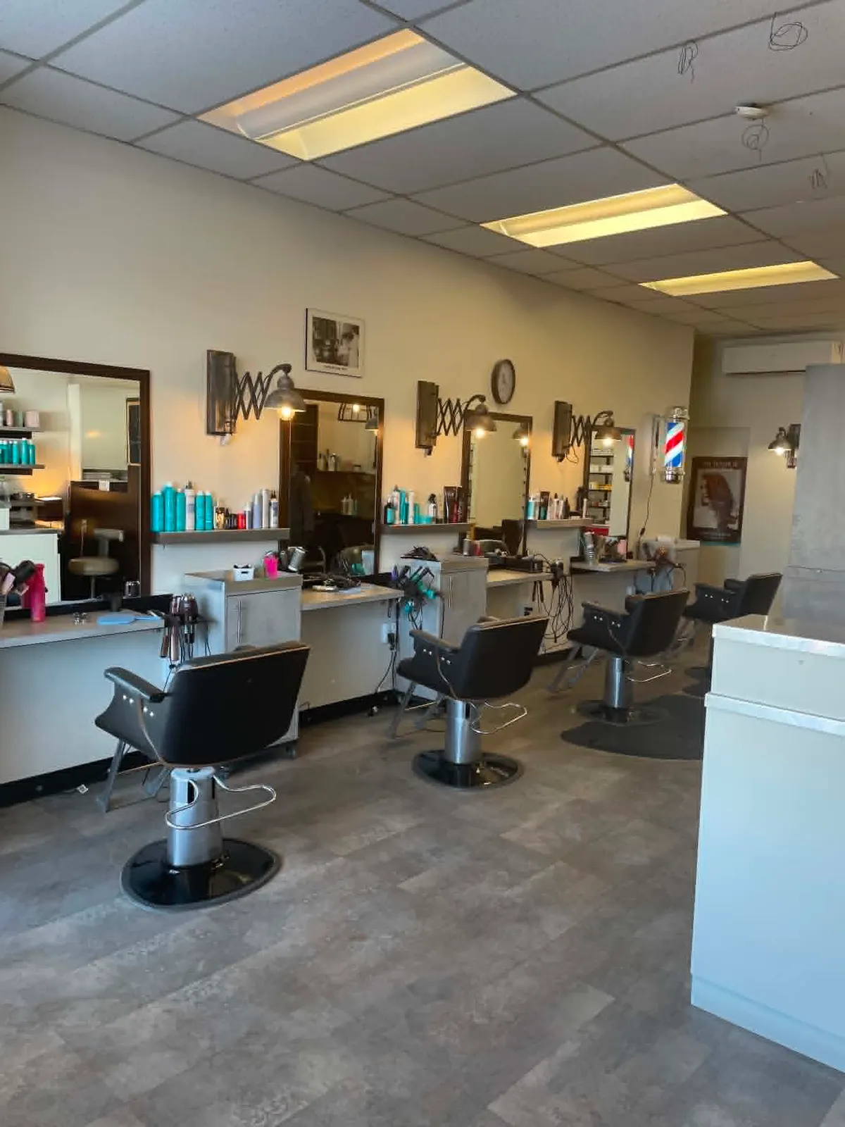 Les postes de coiffure du Salon Guylaine — fauteuils noirs, grands miroirs et produits de soin.