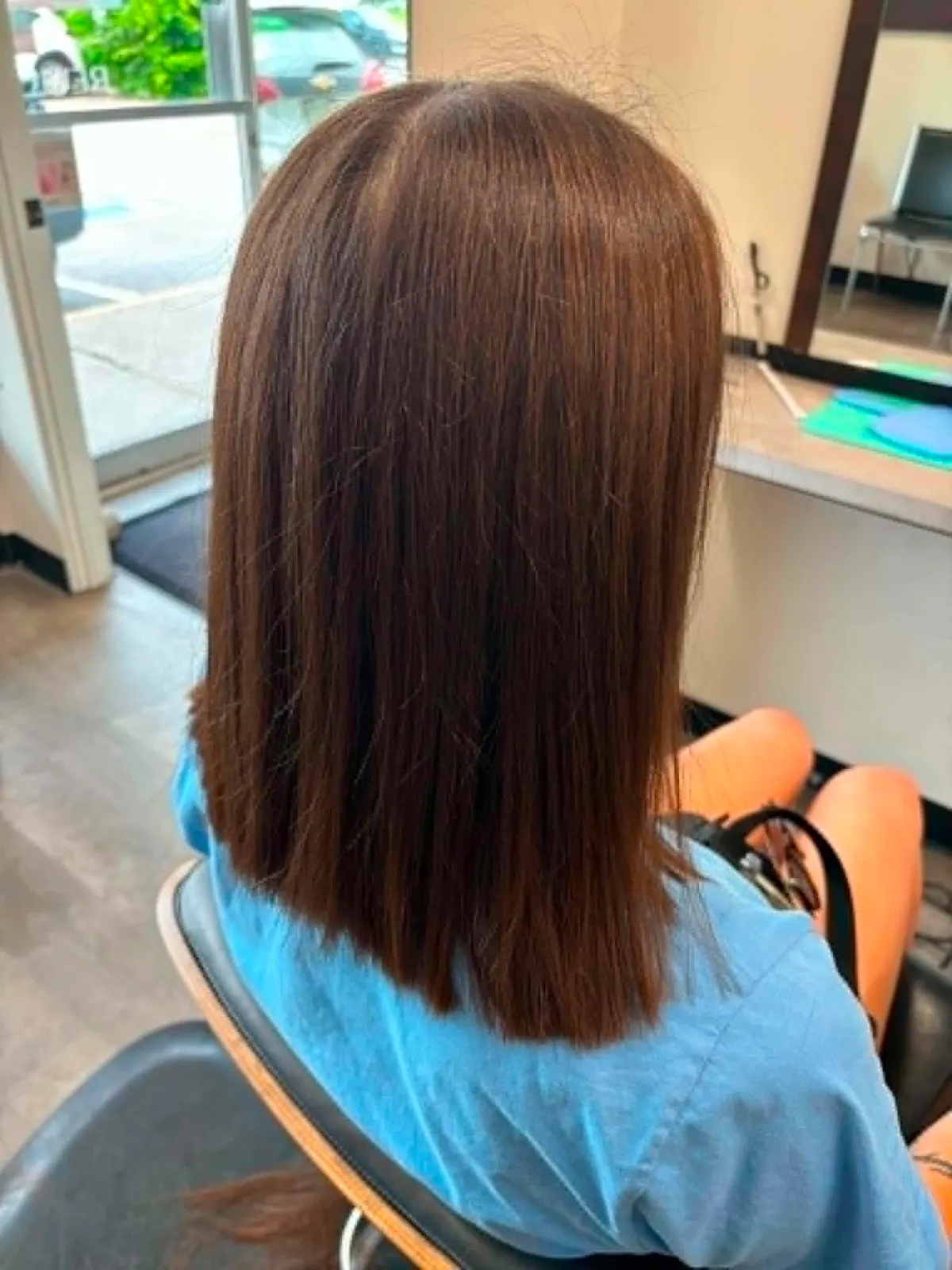 Cheveux bruns lissés et brillants, coiffés au Salon Guylaine.